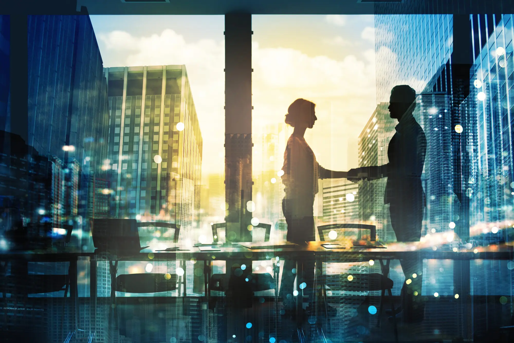 Two business professionals shaking hands in a high-rise office